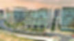 A picture of Embassy tech village in Bangalore, India, there is a road in front of the buildings and there are white cars on the road